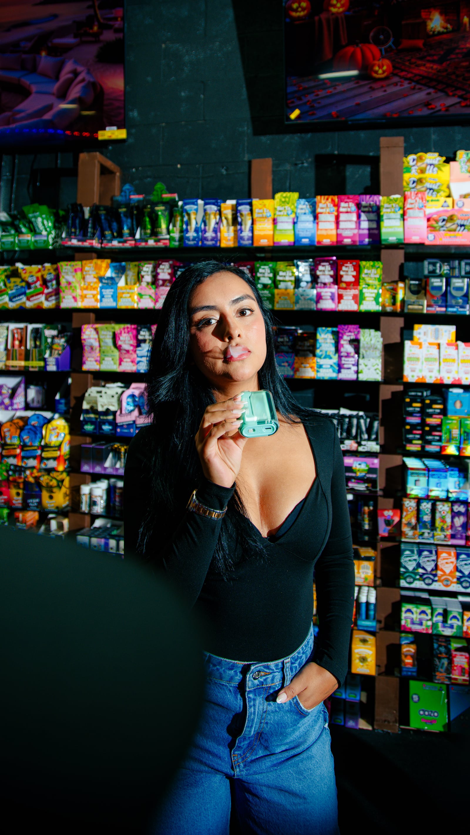 A woman holding a green device in front of stocked shelves inside Zona Verde.